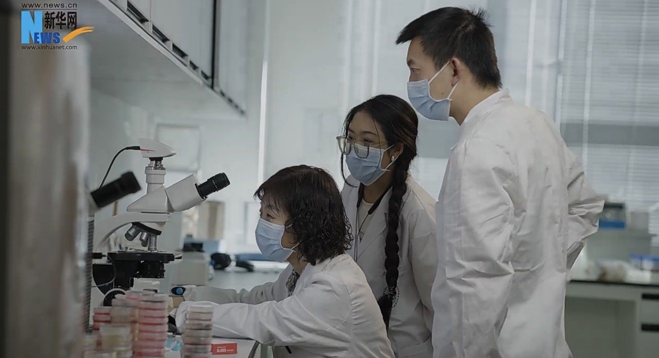 Dr. Lu and her research team at the microscope